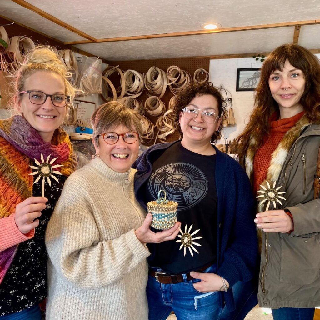 A group of 4 women holding small baskets and smiling.